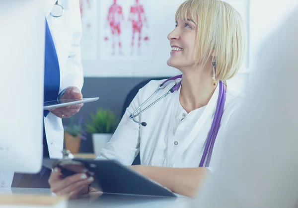 Médecin féminin assis à table avec ordinateur portable, travaillant — Photo