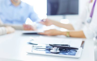 Hastanenin penceresinin yanındaki masada oturan doktor ve hastayı kapat.