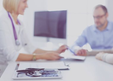 Klinikteki doktor tekerlekli sandalyedeki yaşlı kadından imza istiyor.