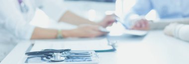 İlgili kıdemli doktor ofisinde yatan hastayı dinliyor.