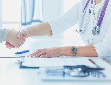 Bayan doktor ofisinde el sıkışıyor.