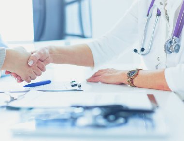 Yaşlı bir çiftle el sıkışan kadın doktor.