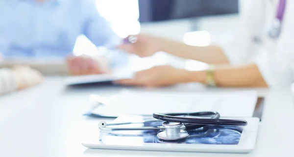 Nahaufnahme von Arzt und Patient, die am Schreibtisch neben dem Fenster im Krankenhaus sitzen — Stockfoto