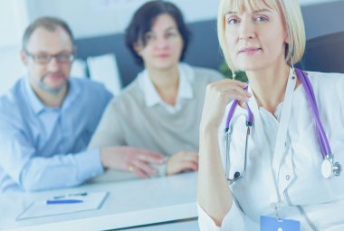 Doktor kadın, masasında erkek hastayla oturuyor.