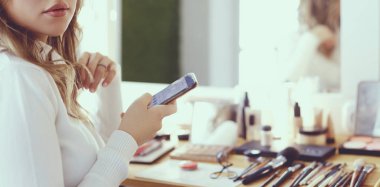 Makyaj sanatçısı genç ve güzel gelinin makyajını yapıyor.