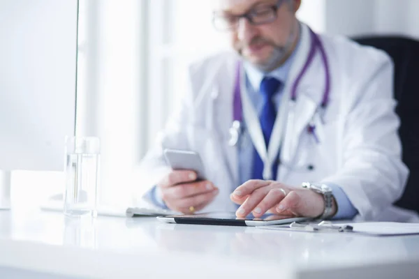 Retrato de médico sênior no escritório sentado na mesa — Fotografia de Stock