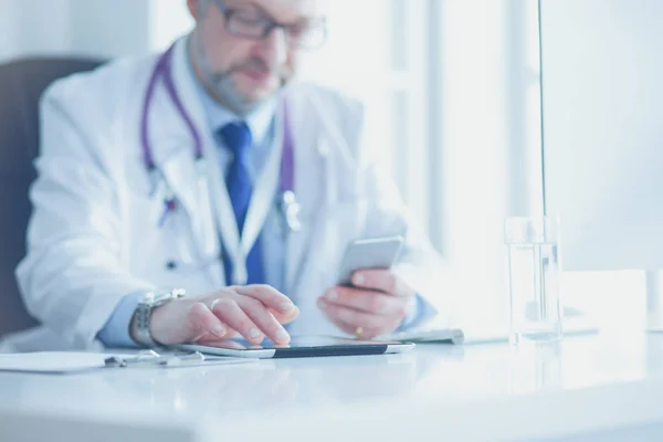 Retrato de médico sênior no escritório sentado na mesa — Fotografia de Stock