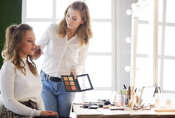 Tvoří umělec dělá profesionální make-up mladé ženy — Stock fotografie