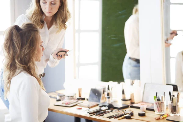 Maquillar artista haciendo profesional maquillaje de mujer joven — Foto de Stock