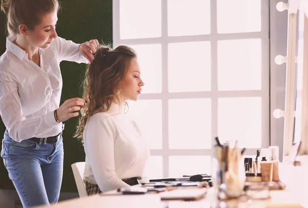 Tvoří umělec dělá profesionální make-up mladé ženy — Stock fotografie