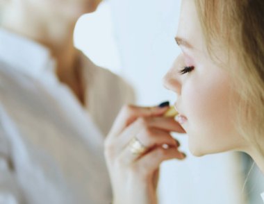 Güzel, genç bir model kadın makyaj yaptırıyor.