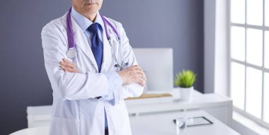 Parlak ofisinde gülümseyen bir doktorun portresi.