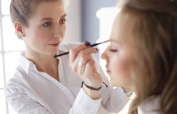 Hermosa joven modelo mujer consiguiendo maquillaje de moda — Foto de Stock