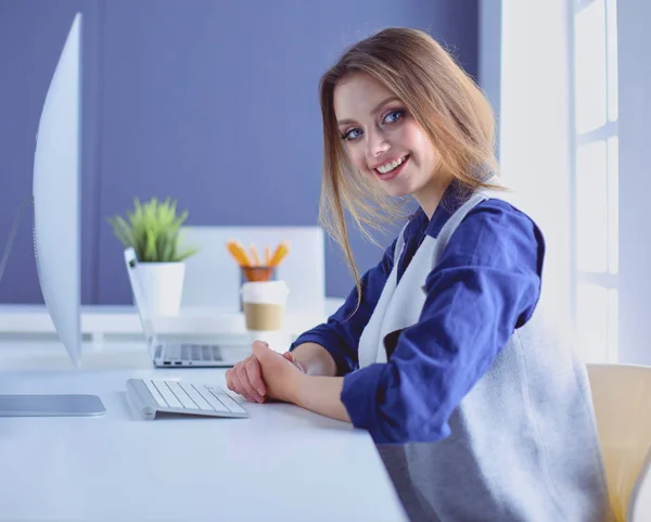 Joven empresaria confiada trabajando en el escritorio de la oficina y escribiendo con una computadora portátil — Foto de Stock