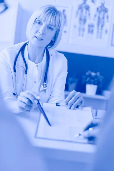 의료 기록이 있는 서류를 진찰하고 있는 의사와 환자가 휠체어에 앉아 있다 — 스톡 사진