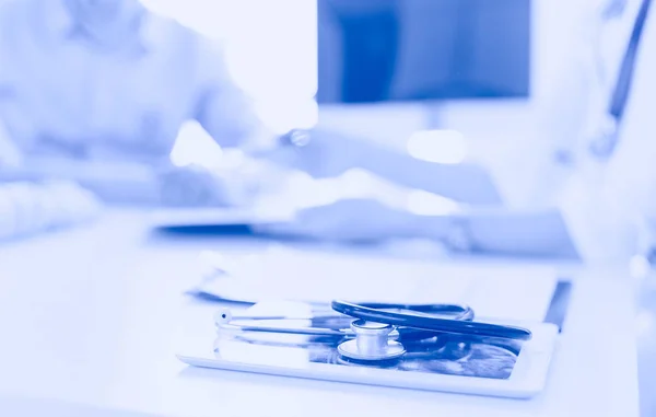 Close up of doctor and patient sitting at the desk near the window in hospital — Stock Photo, Image