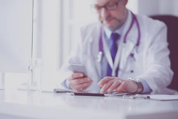 Retrato de médico sênior no escritório sentado na mesa — Fotografia de Stock