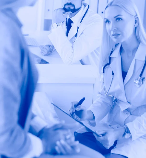 Arzt und Patient diskutieren etwas, während sie am Tisch sitzen. Medizin und Gesundheitskonzept — Stockfoto