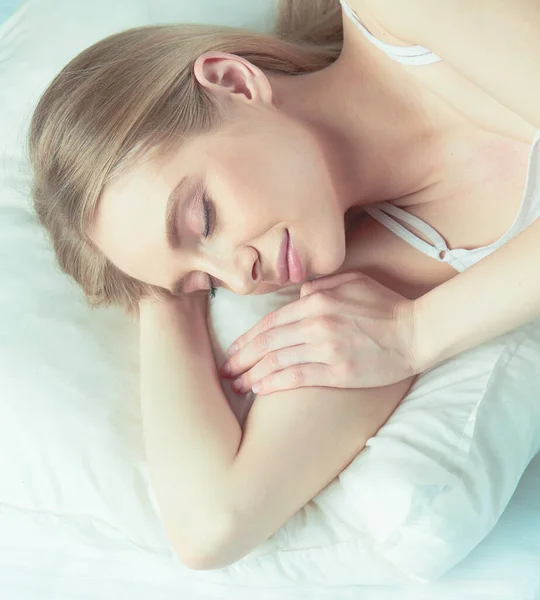 Photo of sleeping young woman lying in bed with eyes closed — Stock Photo, Image