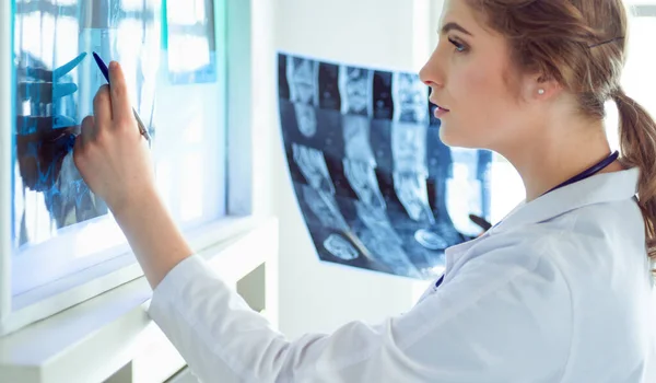 Young female doctor looking at the x-ray picture of lungs in hospital — Stock Photo, Image