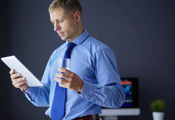 Young serious businessman in headphones looking at tablet screen — Stock Photo, Image