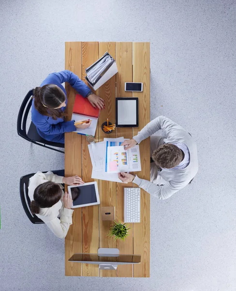 Молодые бизнесмены сидят за столом, работая вместе с ноутбуком — стоковое фото