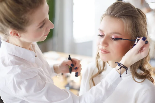 Joven novia hermosa aplicación de maquillaje de boda por el artista de maquillaje profesional — Foto de Stock