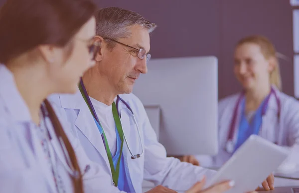 Équipe médicale sérieuse utilisant un ordinateur portable dans un bureau lumineux — Photo