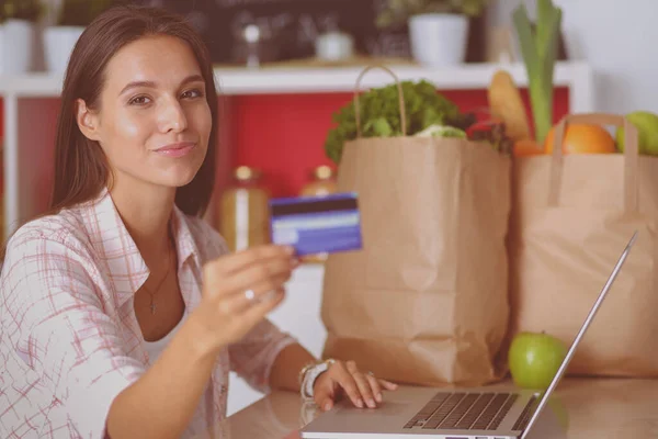 Smiling woman online shopping using tablet and credit card in kitchen . Smiling woman — Stock Photo, Image