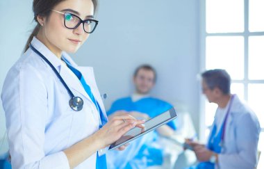 Hastane lobisinde tablet bilgisayar kullanan kadın doktor.