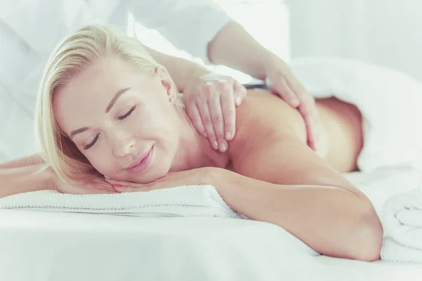 Jovem mulher desfrutando de massagem no salão de spa — Fotografia de Stock