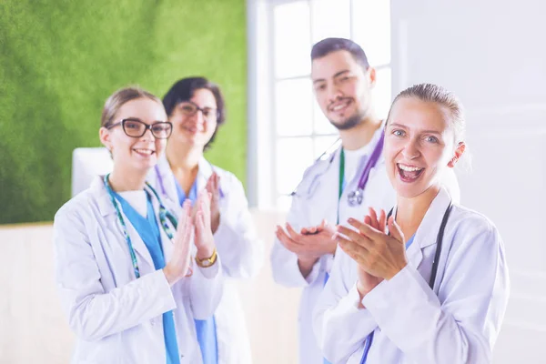 Gelukkig medisch team bestaande uit mannelijke en vrouwelijke artsen brede glimlach en geven een duim omhoog van succes en hoop — Stockfoto