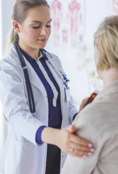 Médico e paciente discutindo algo enquanto se senta na mesa. Conceito de medicina e cuidados de saúde — Fotografia de Stock