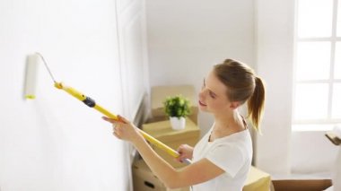 Yeni evin iç duvarlarını boyarken dans eden kadın