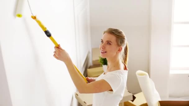 Jeune femme fait des réparations dans un nouvel appartement. Belle fille - mur de peinture dans l'appartement — Video