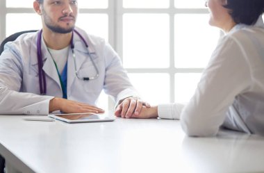 Erkek doktor ambulanstaki hastayı rahatlatıyor.