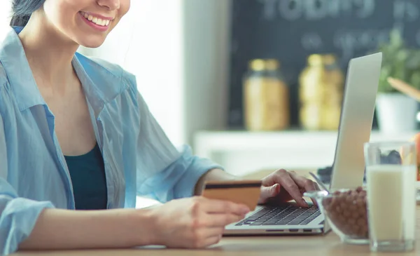 Online vásárlás a tábla és a hitelkártya konyhában mosolygó nő — Stock Fotó