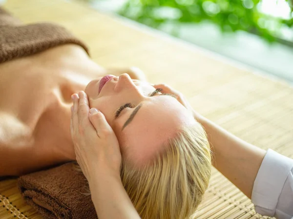 Hermosa mujer haciendo masaje facial en un salón de spa —  Fotos de Stock