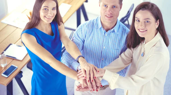 Zakelijke collega 's stapelen handen bij elkaar op kantoor — Stockfoto