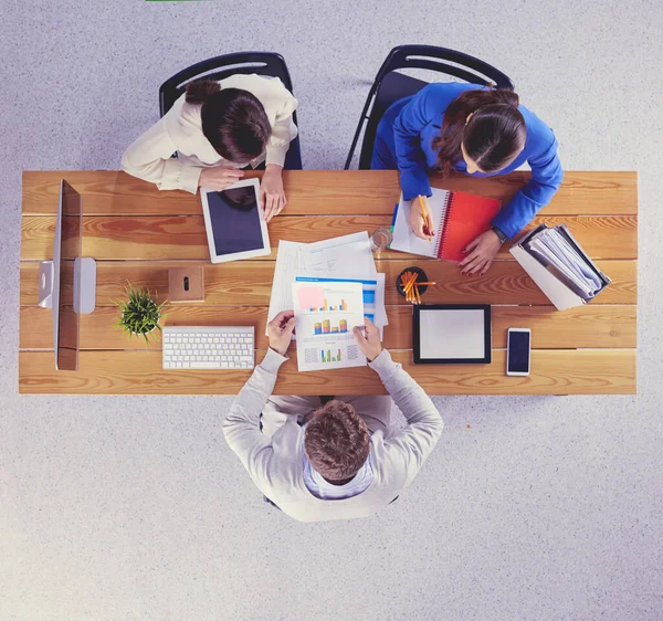 Jovens empresários sentados na mesa trabalhando juntos usando o computador portátil — Fotografia de Stock