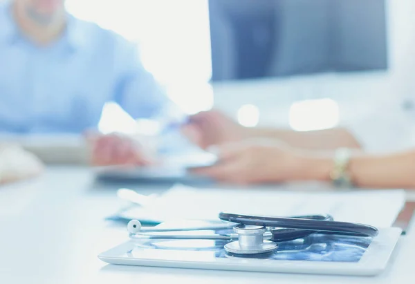 Close up of doctor and patient sitting at the desk near the window in hospital — Stock Photo, Image