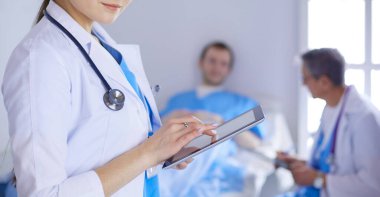 Hastane lobisinde tablet bilgisayar kullanan kadın doktor.