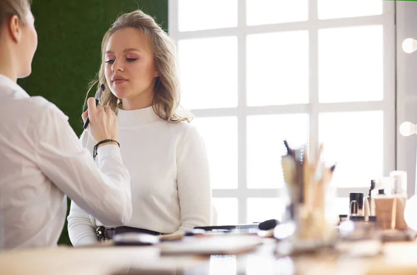 Make-up artist facendo make-up per la giovane bella sposa applicare il trucco di nozze — Foto Stock