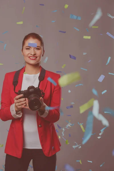 Schöne, glückliche Frau mit Kamera bei einer Feier mit Konfetti. Geburtstag oder Silvester feiern Konzept — Stockfoto