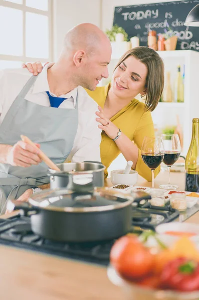 요리하기를 좋아하는 매력적 인 남녀가 낭만적 인 저녁 식사를 준비하면서 부엌에서 포도주를 따고 있다 — 스톡 사진