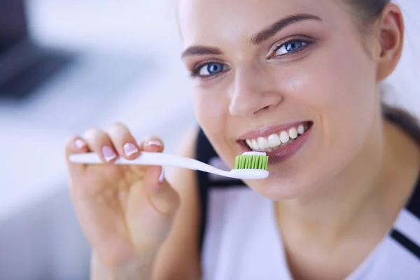 Joven chica bonita manteniendo la higiene bucal con cepillo de dientes . — Foto de Stock