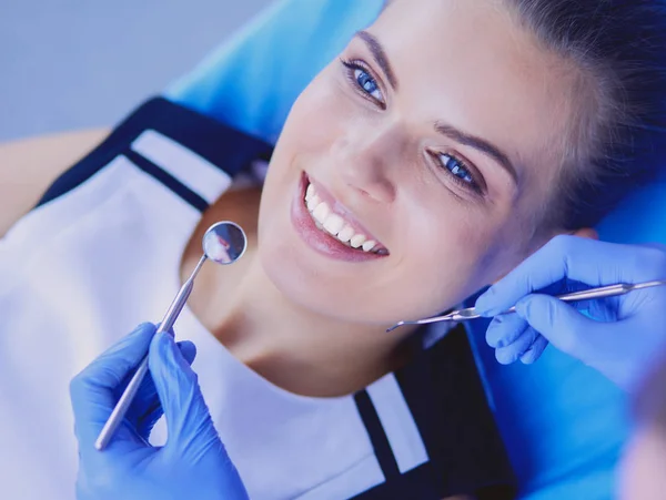Ung kvinnlig patient med vackert leende undersöker tandläkarkontroll på tandläkarmottagningen. — Stockfoto