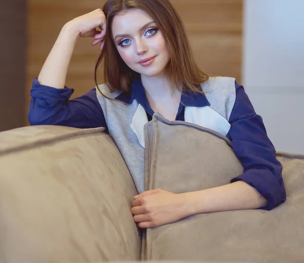 하얀 소파에 앉아 있는 여자 — 스톡 사진