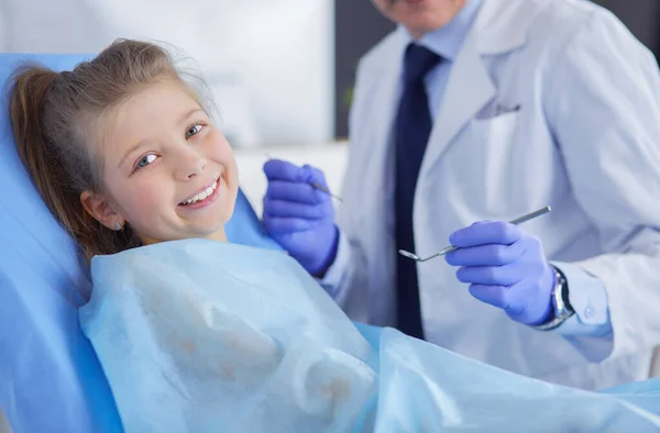 Niña sentada en el consultorio de dentistas — Foto de Stock