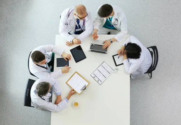 Medical team sitting and discussing at table, top view